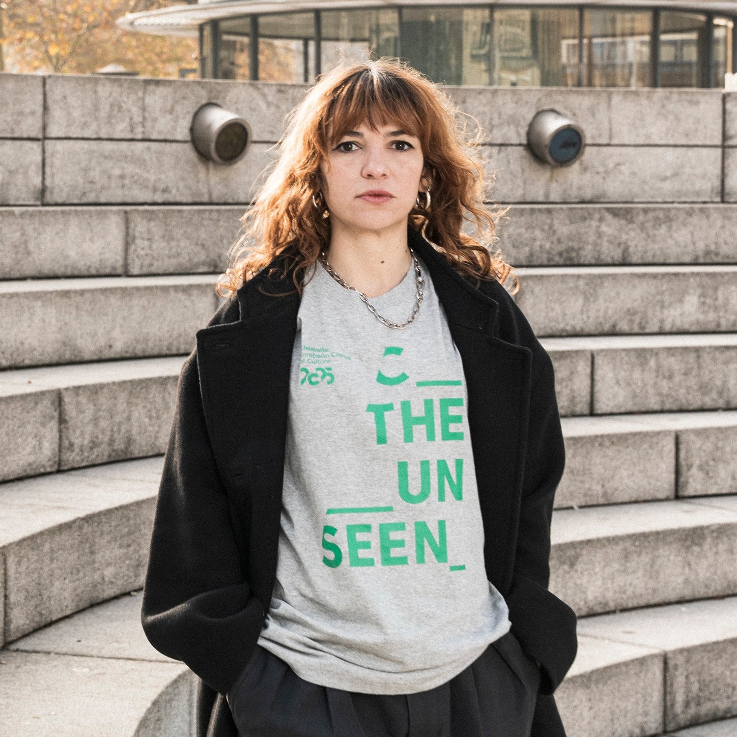 Jüngere Frau präsentiert T-Shirt aus der Kollektion