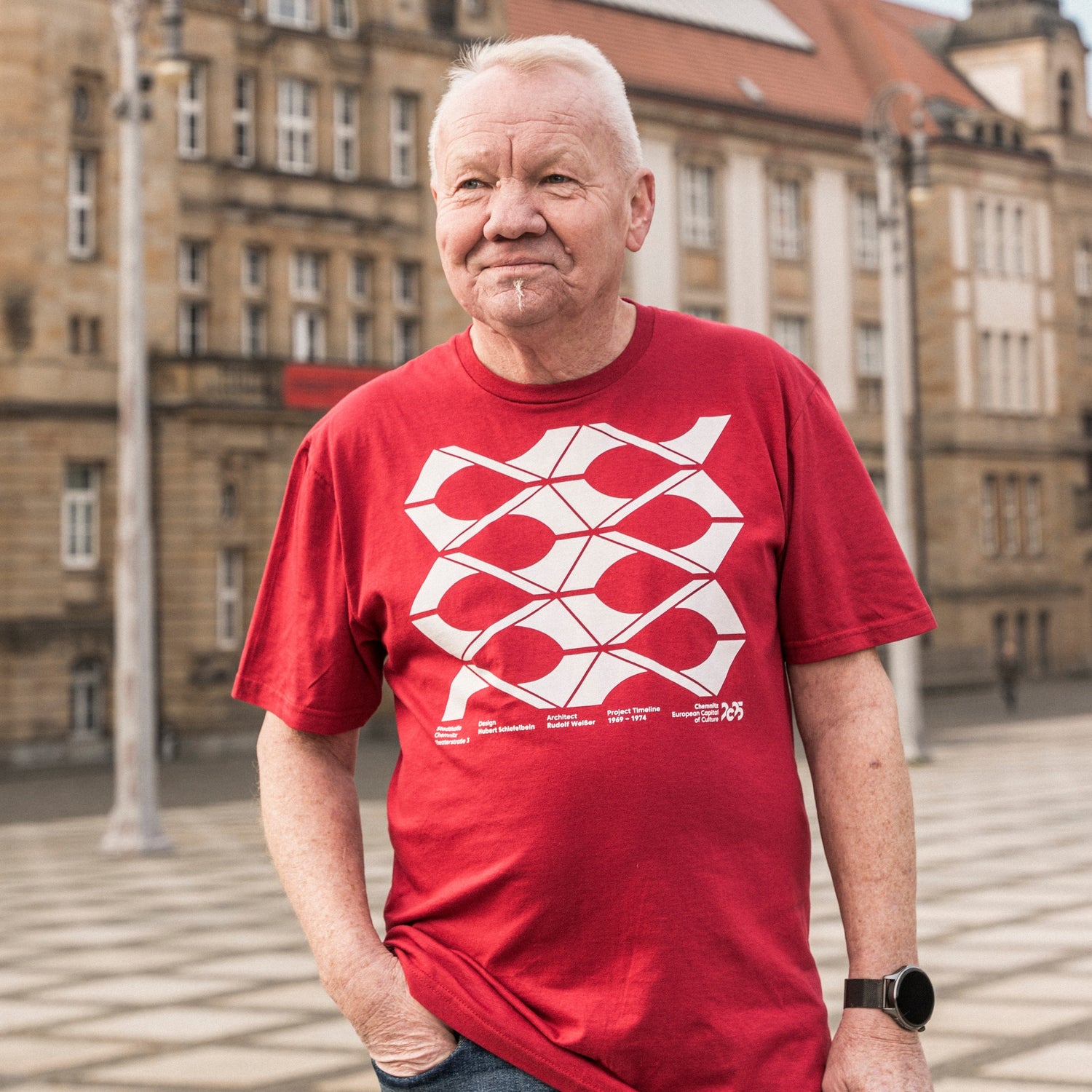 Älterer Mann präsentiert T-Shirt aus der Kollektion