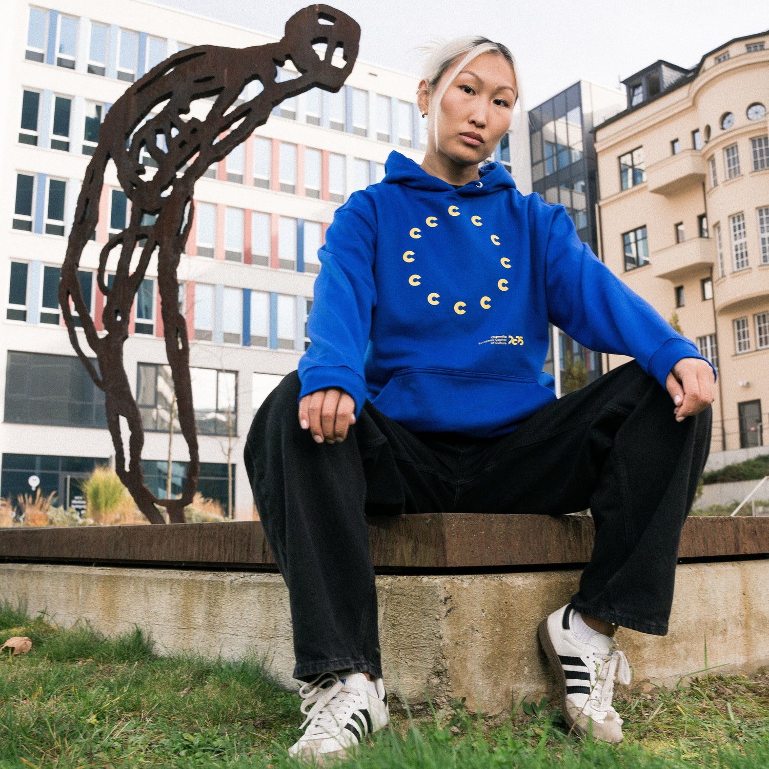 Jüngere Frau präsentiert Hoodie aus der Kollektion
